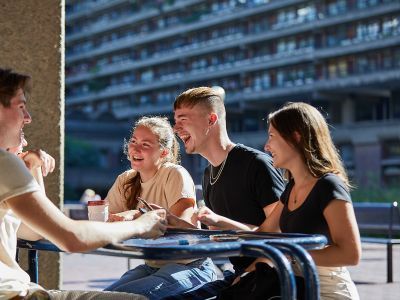 Four students outside on lakeside terrace
